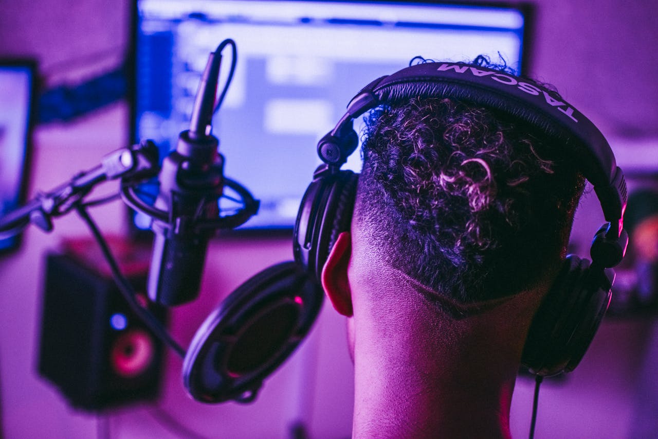 Back view of a music producer working in a vibrant recording studio setting.